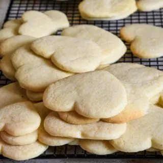 A stack of heart shaped cookies on a cooling rack.