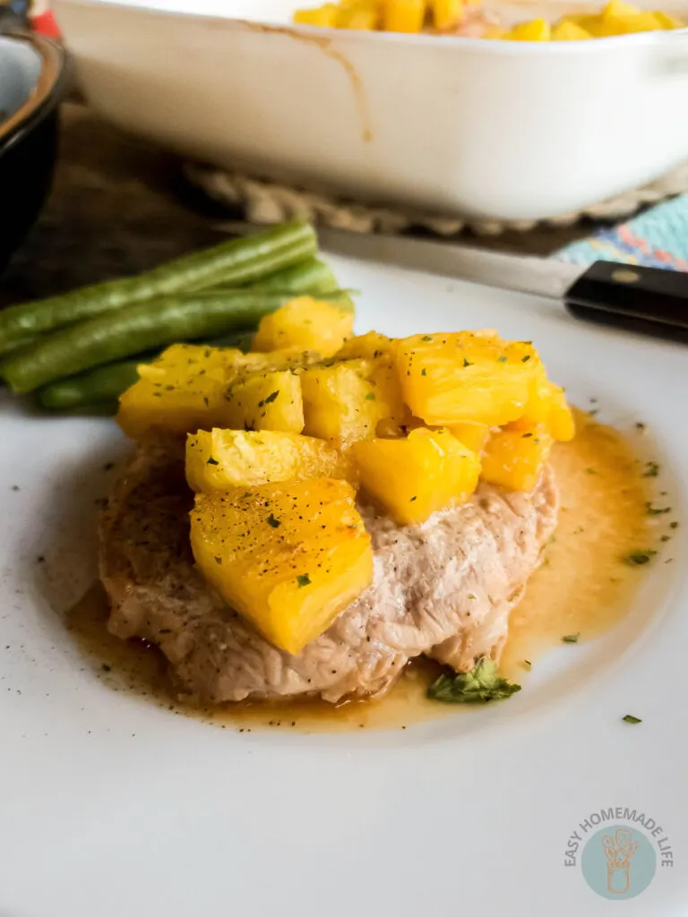 Baked pineapple teriyaki pork chop up close with pineapple chunks on top