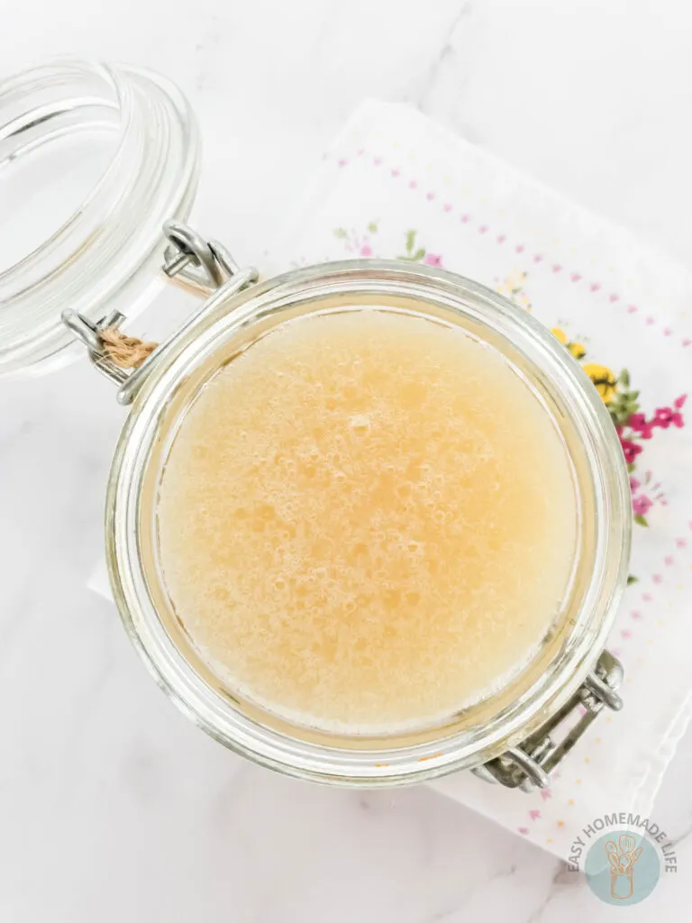 An opened jar of honey body scrub.