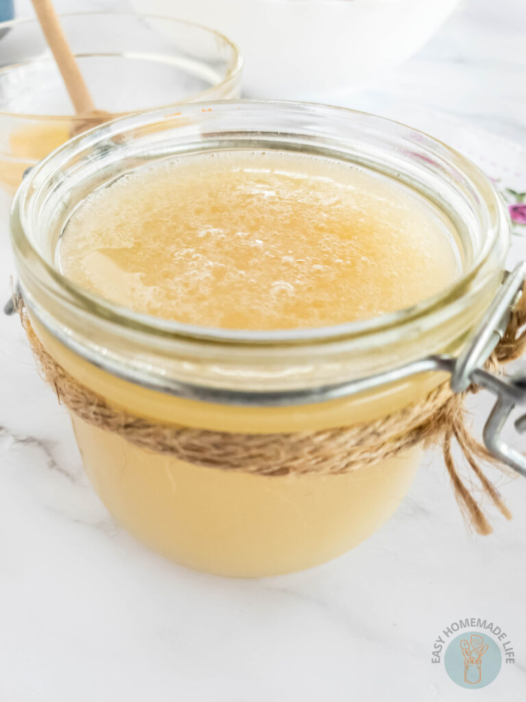 An opened jar of Honey body scrub wrapped with twine.