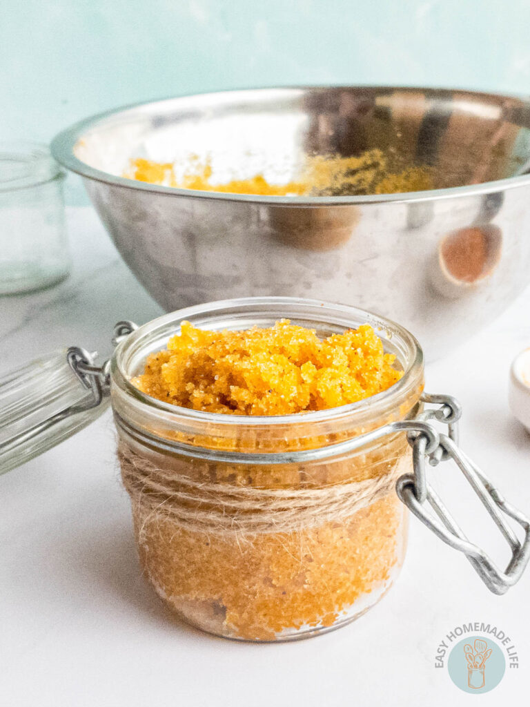 A jar of turmeric body scrub with open lid.