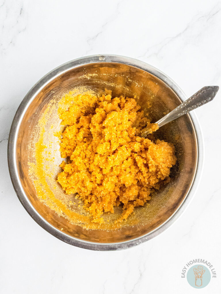 Turmeric body scrub ingredients in a mixing stainless steel bowl.