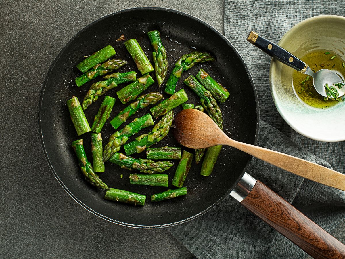 Asparagus cooking in a frying pan.