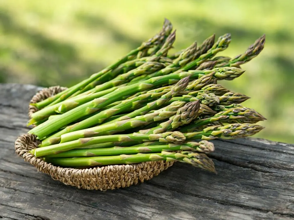 Asparagus stalks in a brown basket.