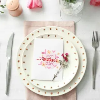 Place setting at a table with a Happy Mother's Day card on the plate.