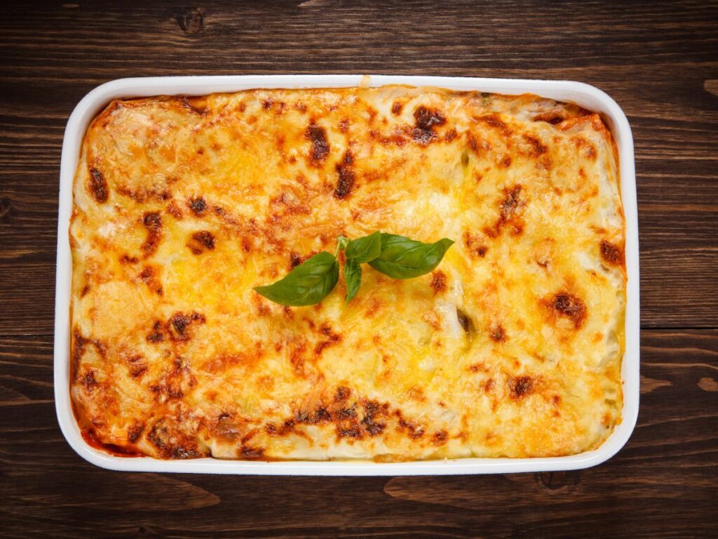 Whole lasagna in a white baking dish.