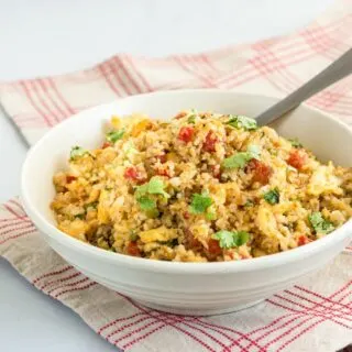 cauliflower rice recipe in a bowl with fork and veggies