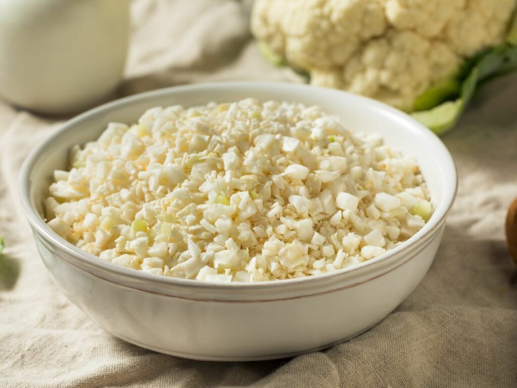 Fresh grated cauliflower rice in a white bowl.
