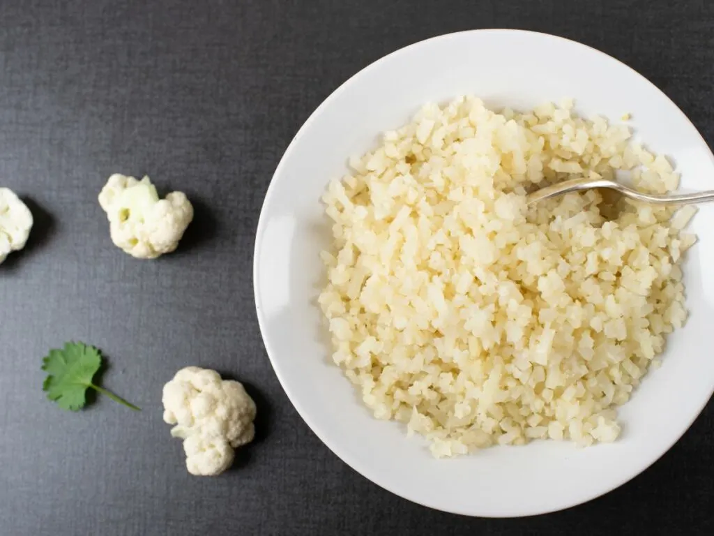 Cauliflower rice in a white bowl.