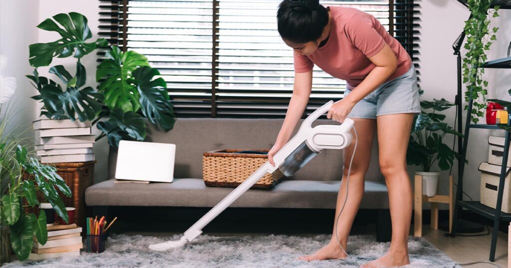 A woman cleaning the carpet.