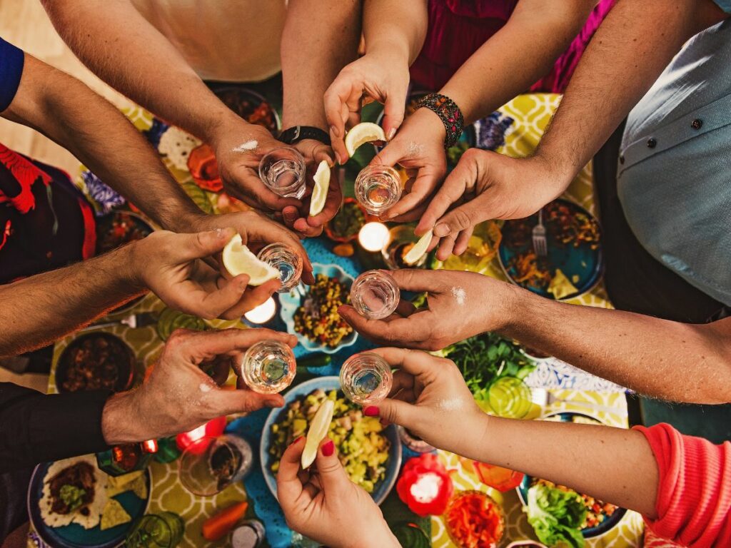 Friends drinking tequila at taco party.