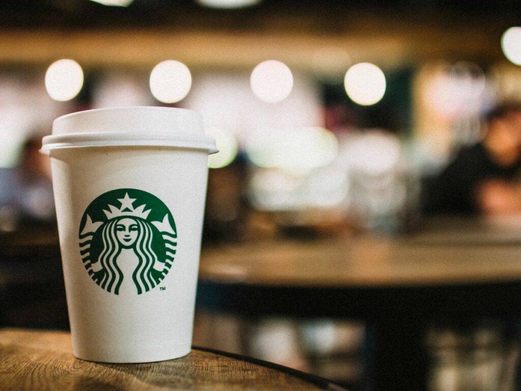 A cup of starbucks drink on a wooden table.