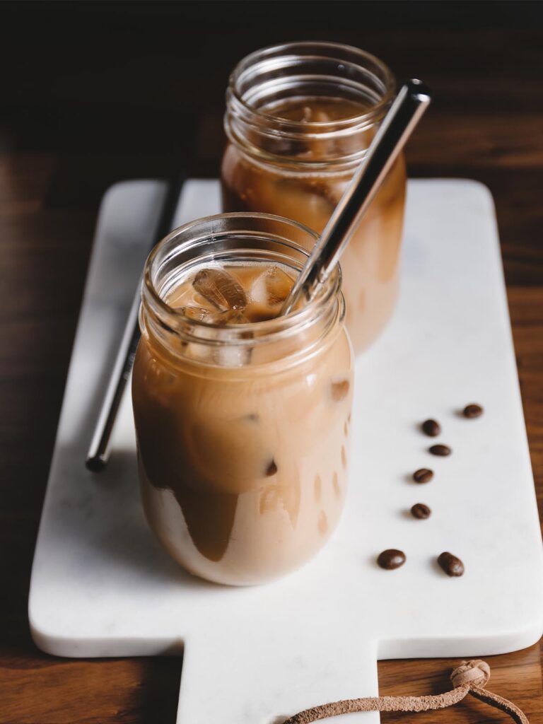 Two jars of Chick-Fil-A's iced coffee with reusable metal straws.