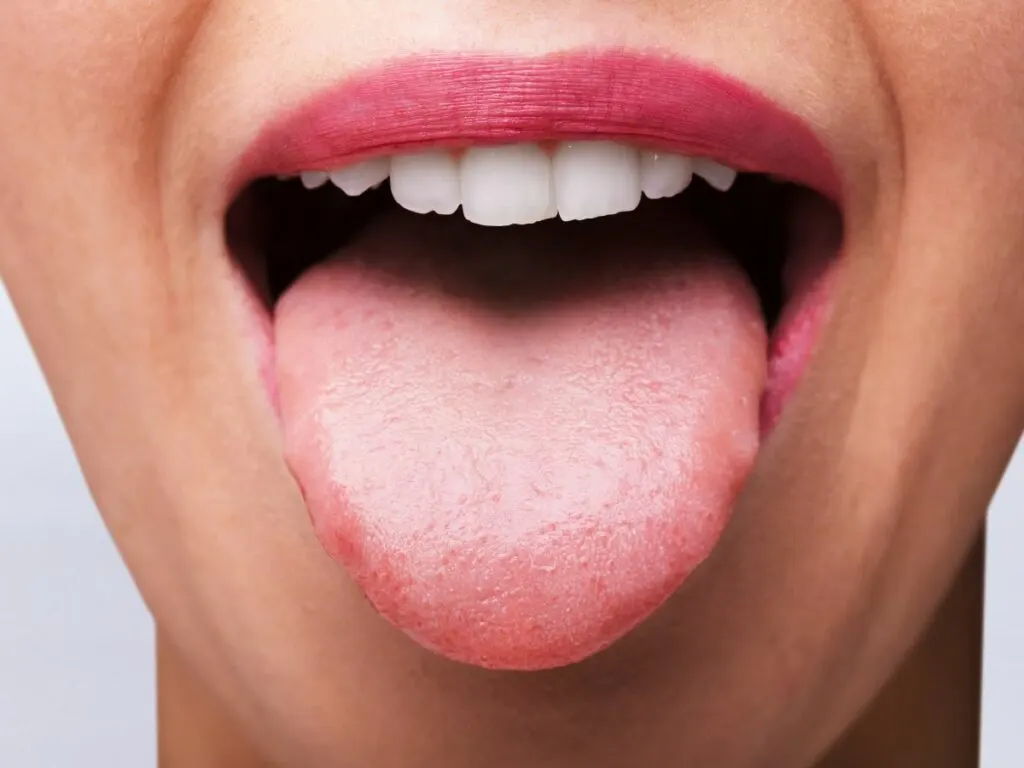 A woman's open mouth with tongue out.