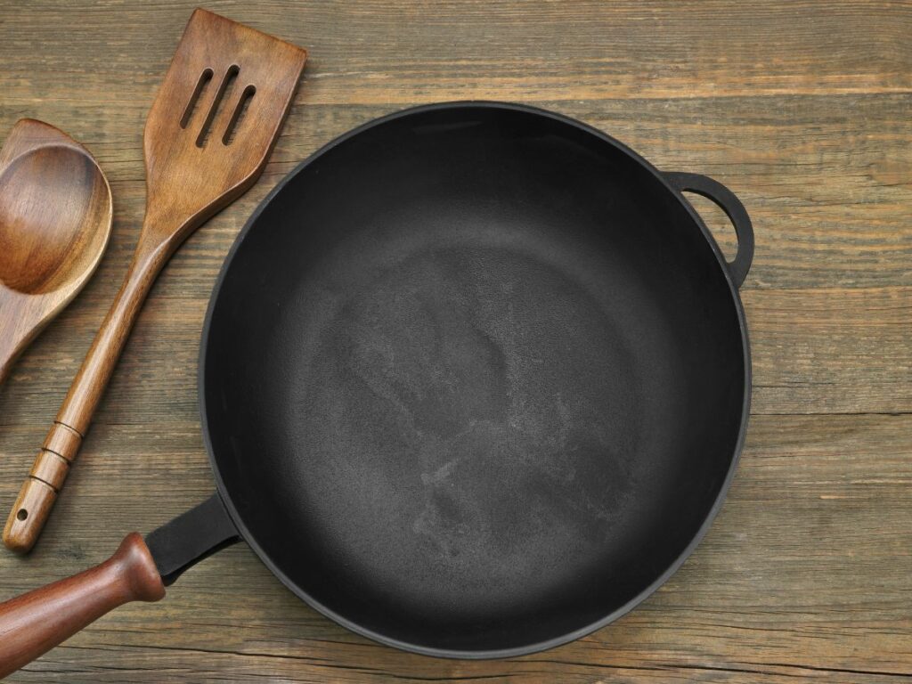 An old cast iron skillet with wooden utensils.