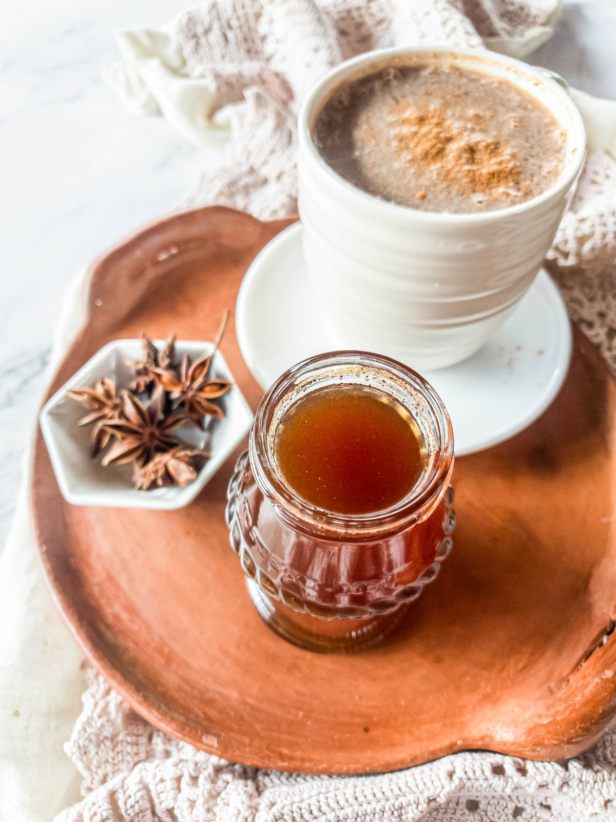 Terra cotta tray over crochet table runner with latte, simple syrup, and star anise.