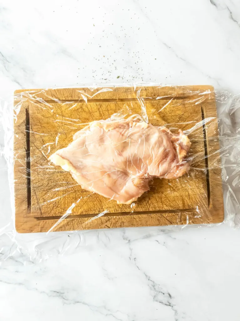 Flattened chicken breast on cutting board.
