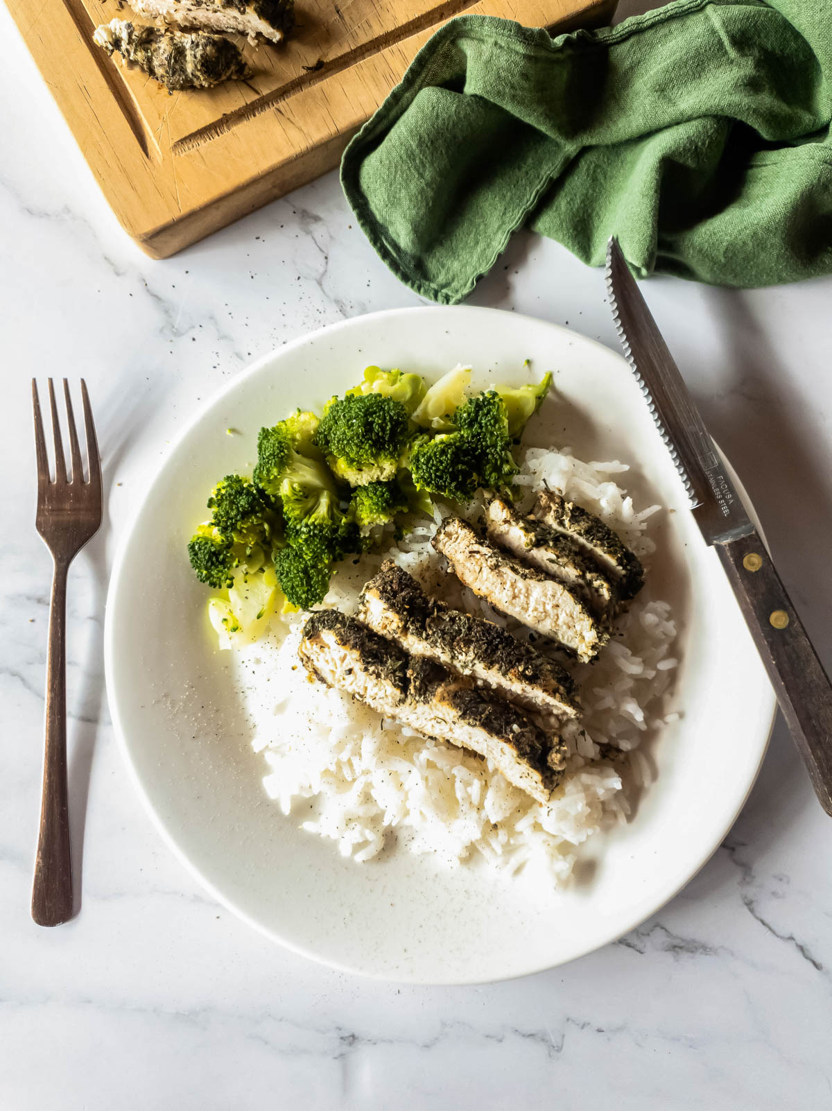 Copycat Texas Roadhouse chicken over rice with broccoli side.