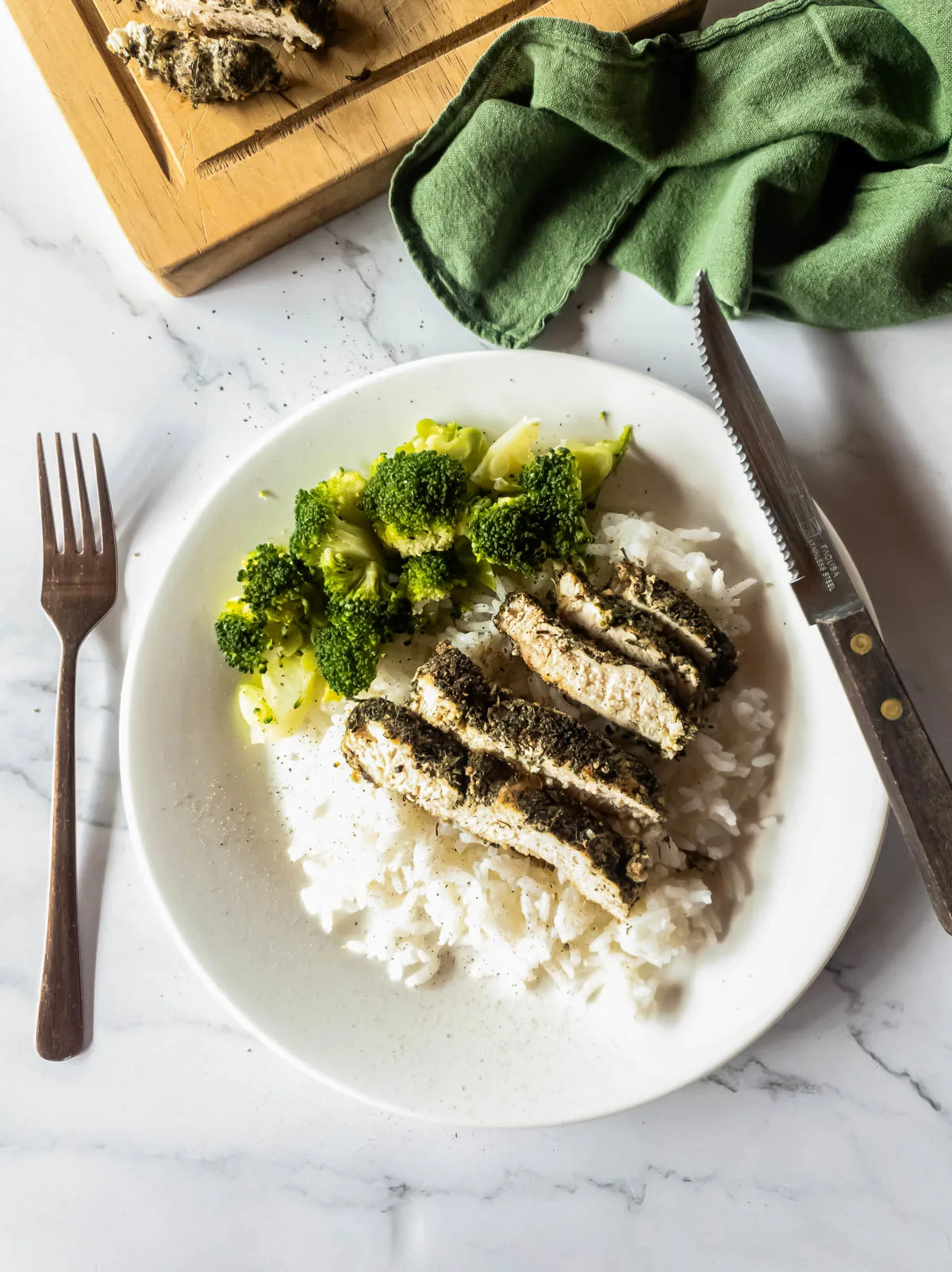 A picture of copycat Texas Roadhouse chicken over rice with broccoli side.