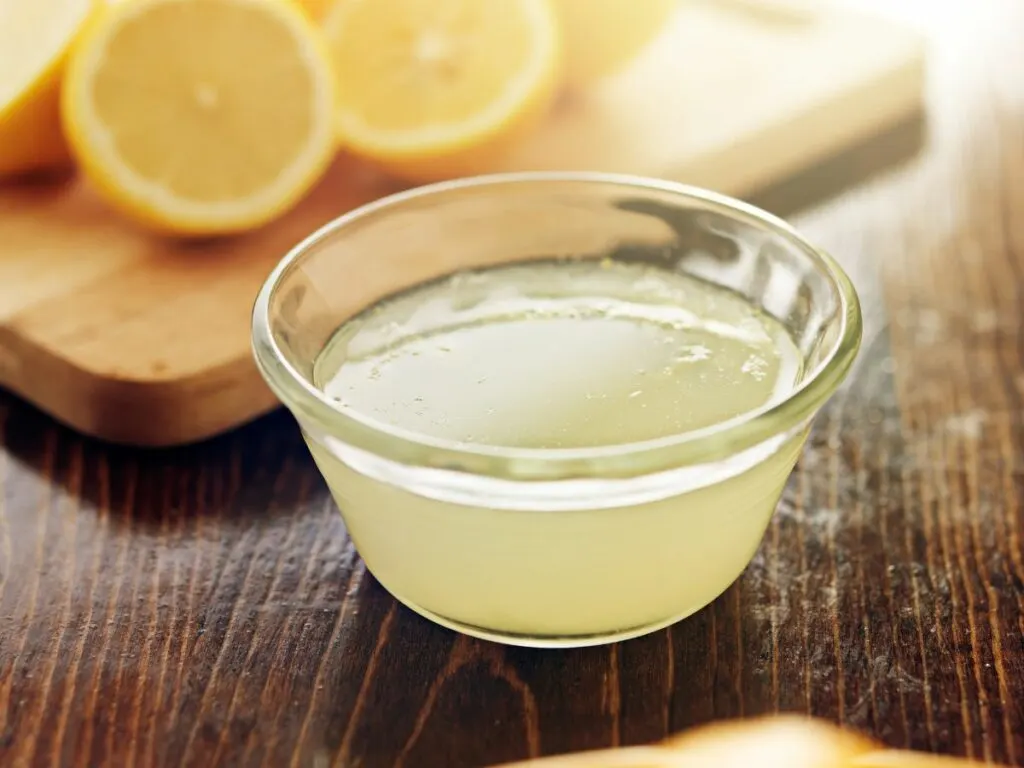 Freshly squeezed lemon juice in small clear glass bowl.