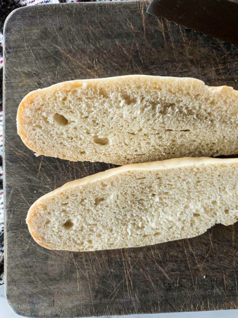 Jimmy John's bread cut open lengthwise on a cutting board.