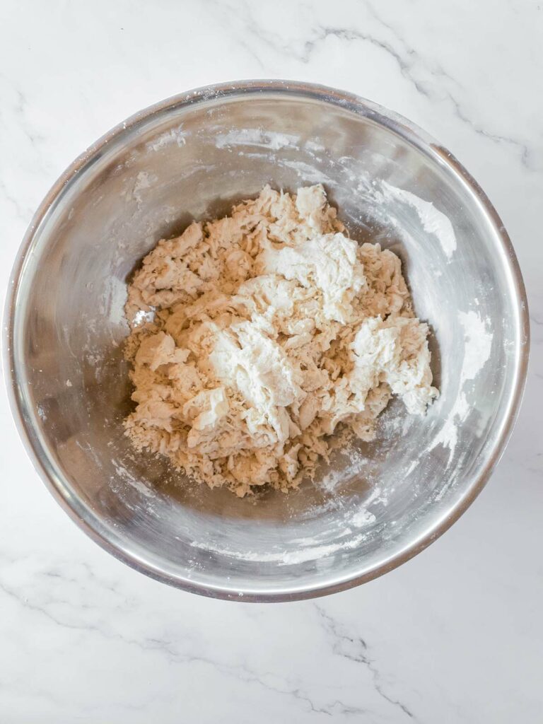 A bowl of dough for Jimmy John's bread on a marble countertop.