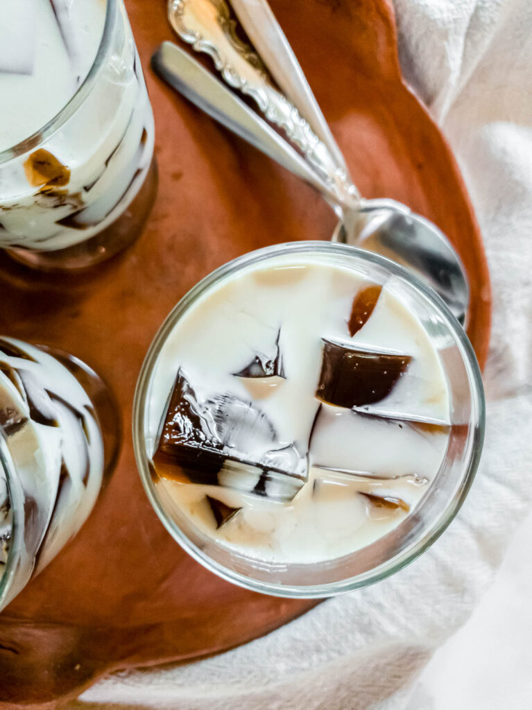 Three glasses of chilled saiki k coffee jelly on a terra cotta plate.