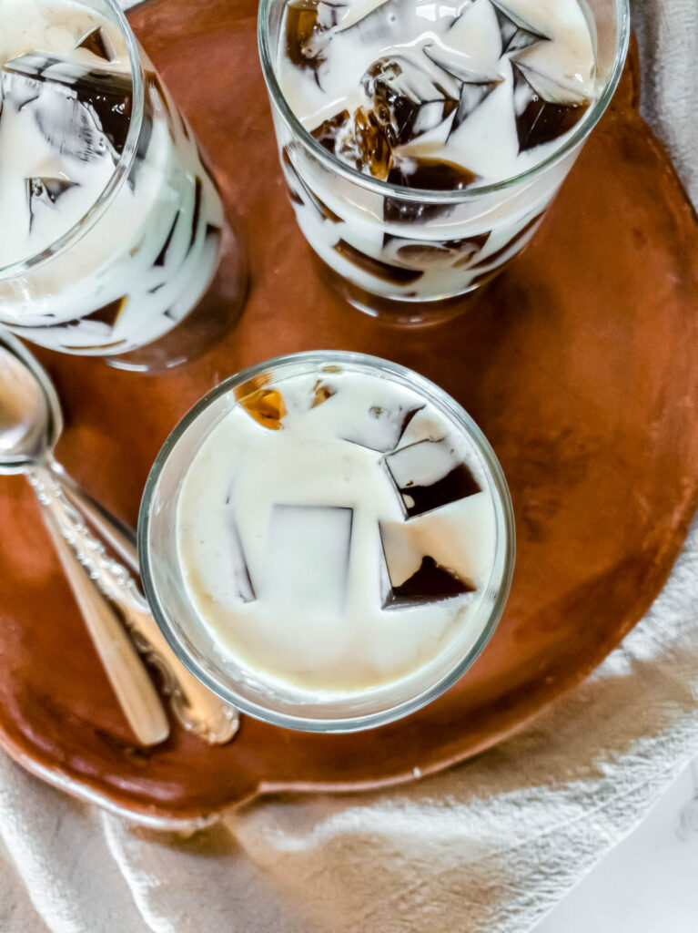 Three glasses of saiki k coffee jelly on a terra cotta plate.