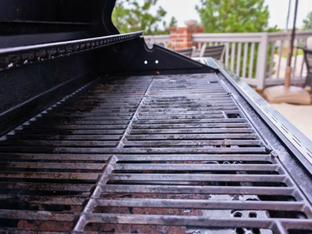 A close up of a bbq grill on a patio.