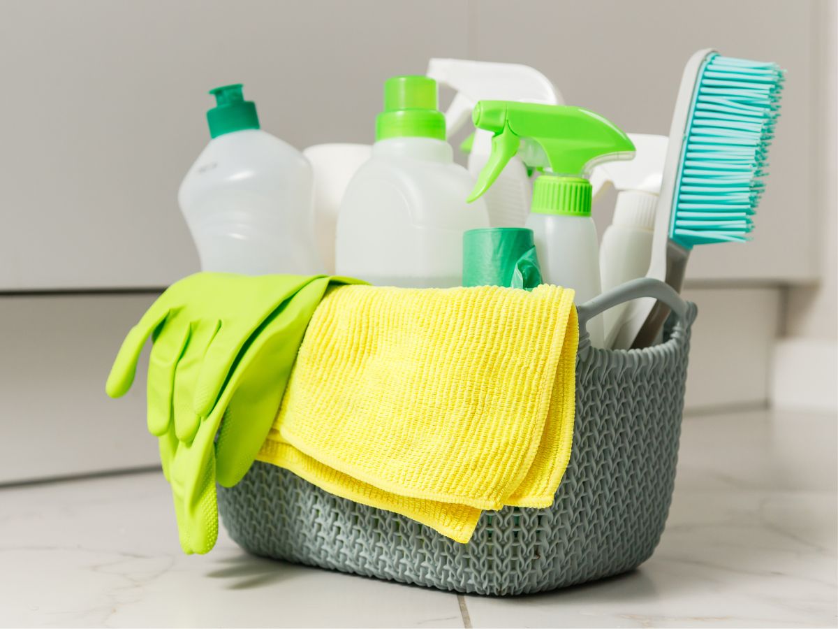 Cleaning supplies for removing red stains in a basket on a kitchen counter.