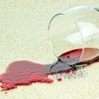 A red stain on carpet caused by fresh spilled red wine.