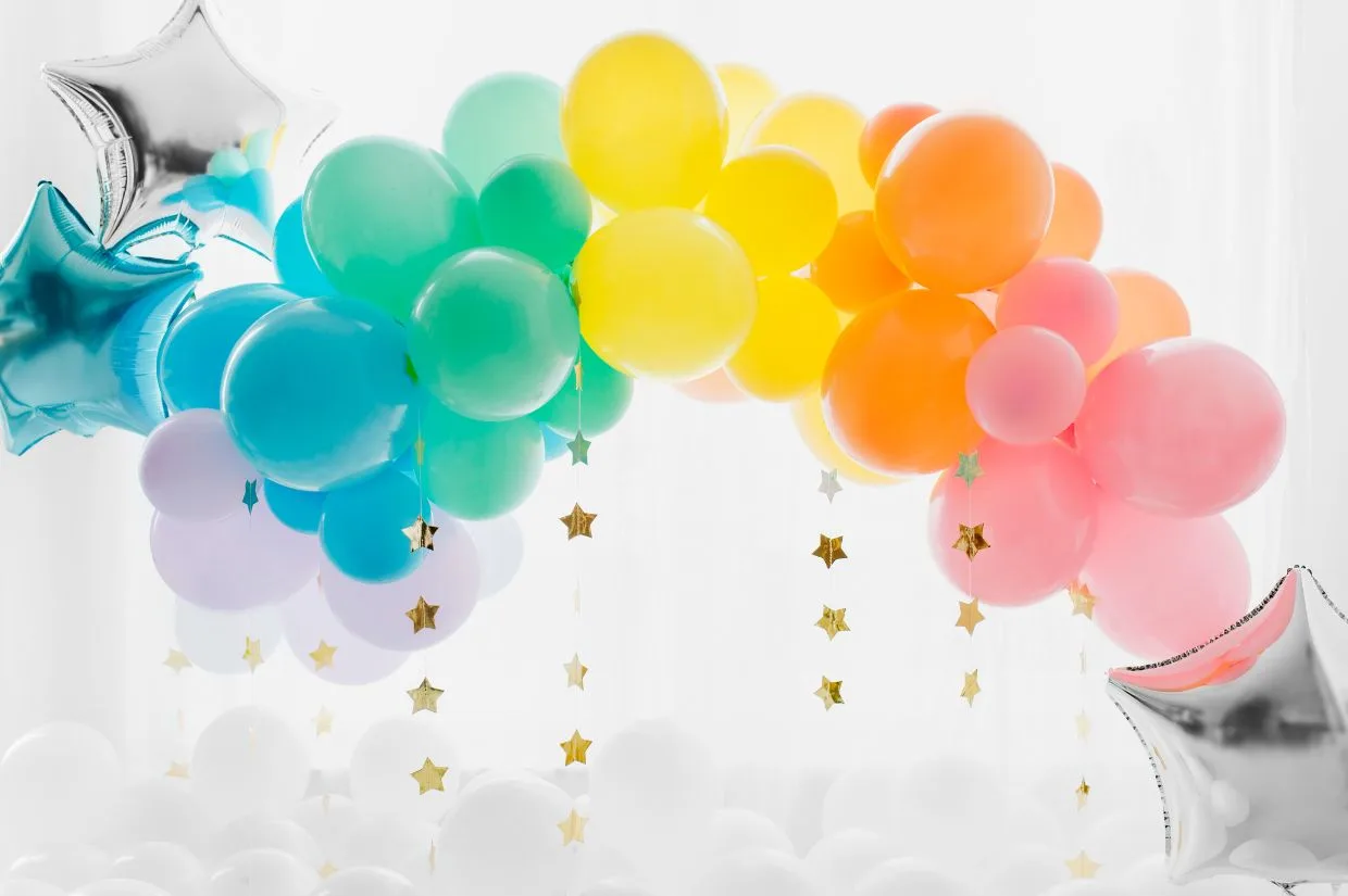A rainbow balloon arch with stars and balloons.
