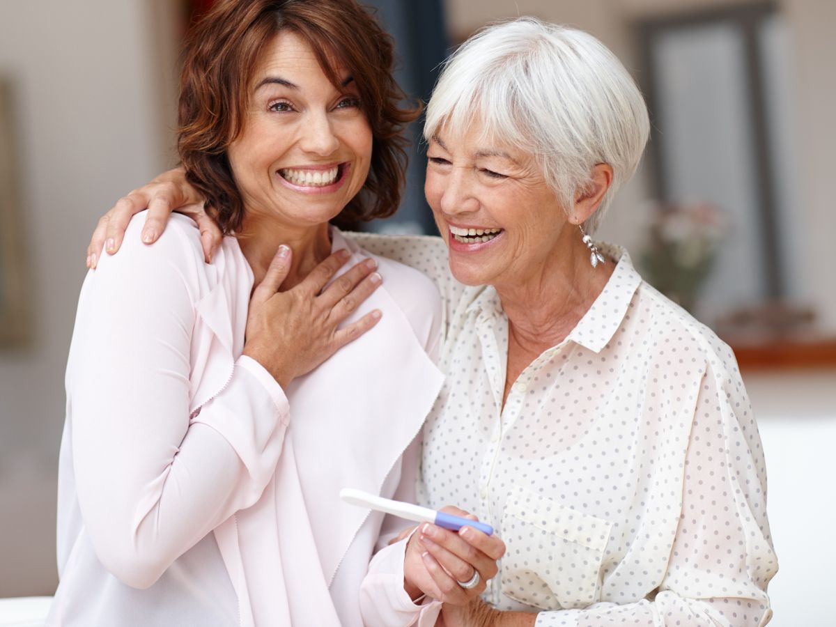 Mother and daughter celebrating a positive pregnancy test result.