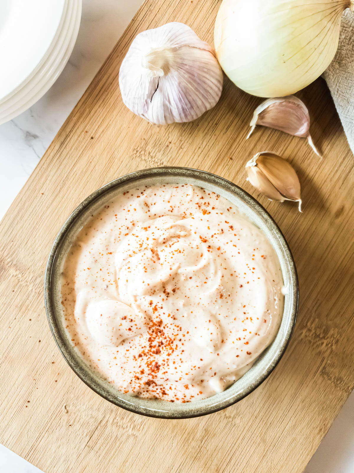 A bowl of Popeyes spicy mayonnaise with onion and garlic.