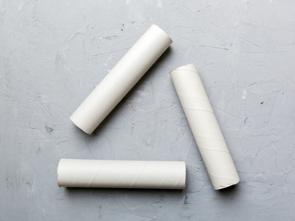 Gray surface with three rolls of white toilet paper.