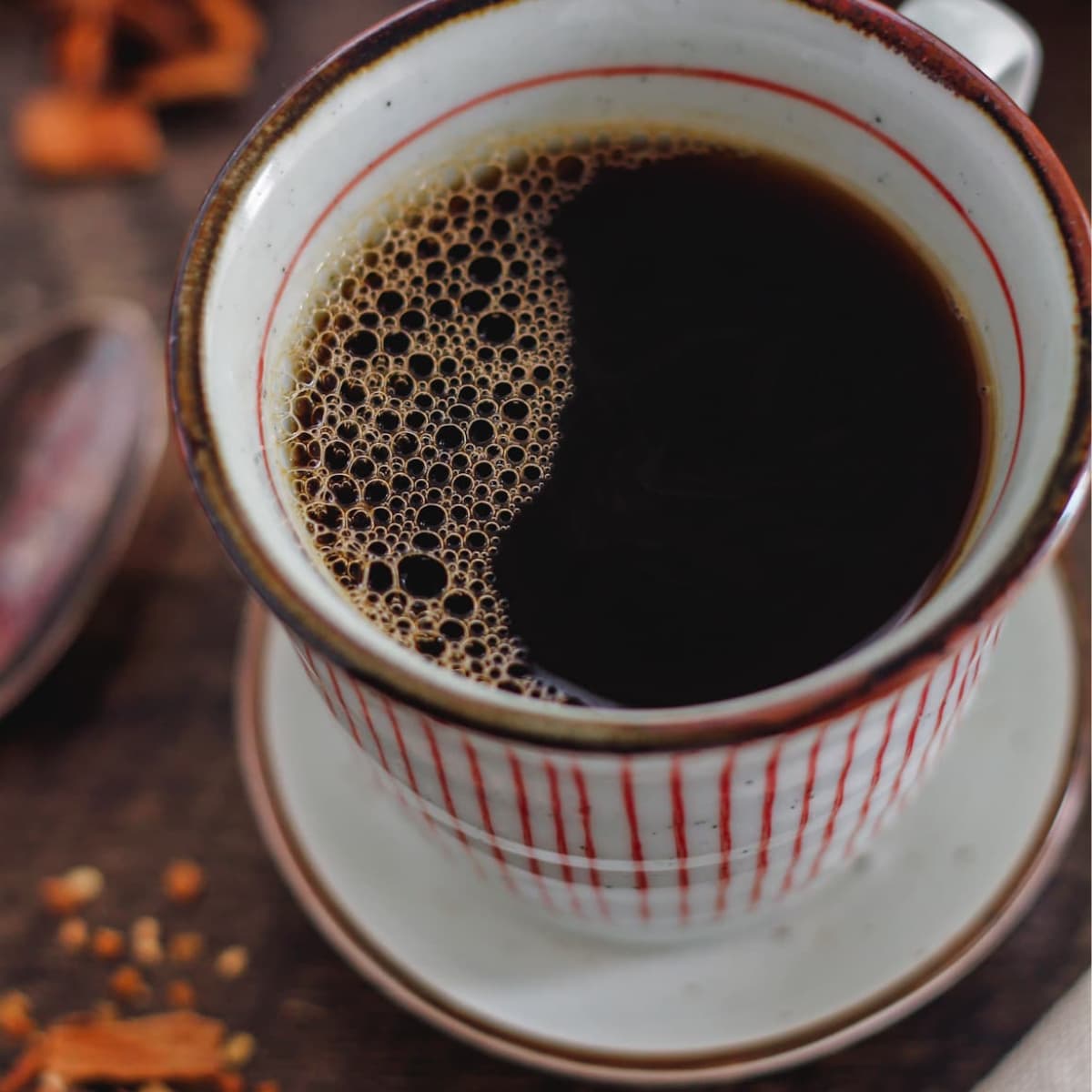 A cup of coffee on a wooden table.