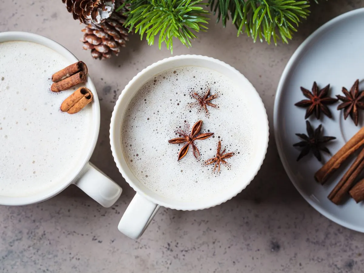 Two cups of hot cocoa with cinnamon and star anise.