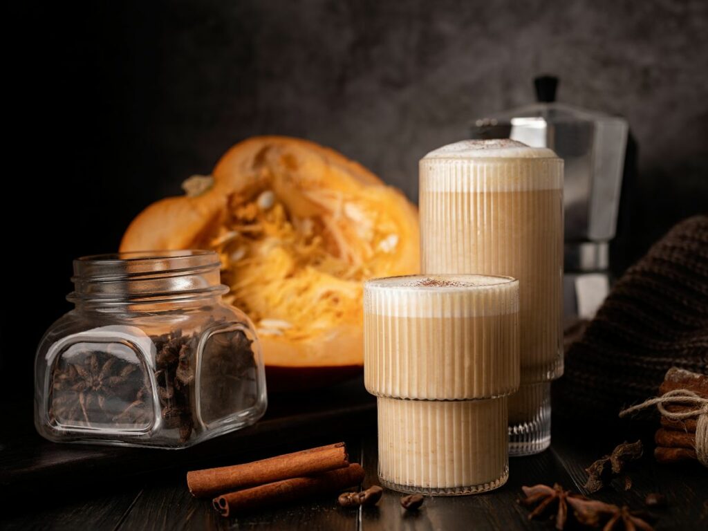 A pumpkin latte with cinnamon and spices on a dark background.