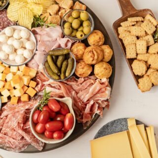 A charcuterie board of meats, cheeses, and crackers.