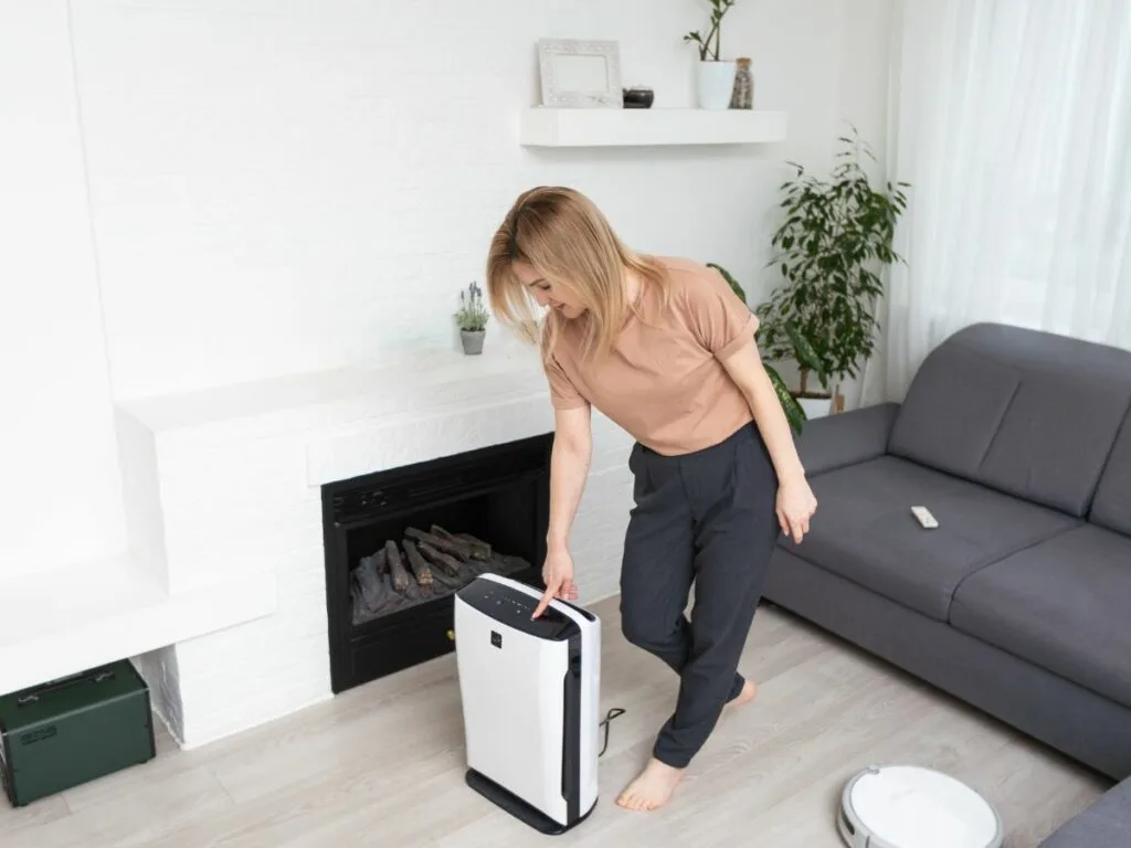 A woman using a dehumidifier in her living room.
