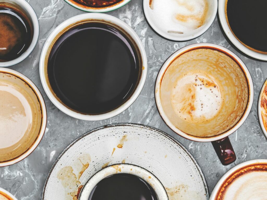 A group of coffee cups and saucers on a table.