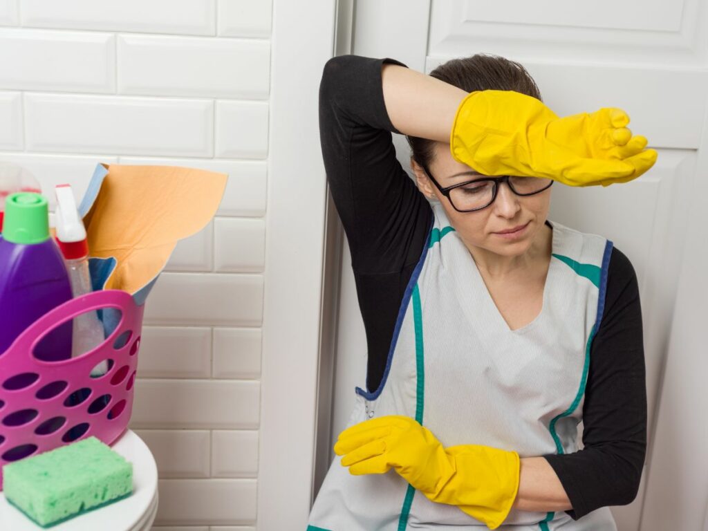 A woman in an apron is cleaning.