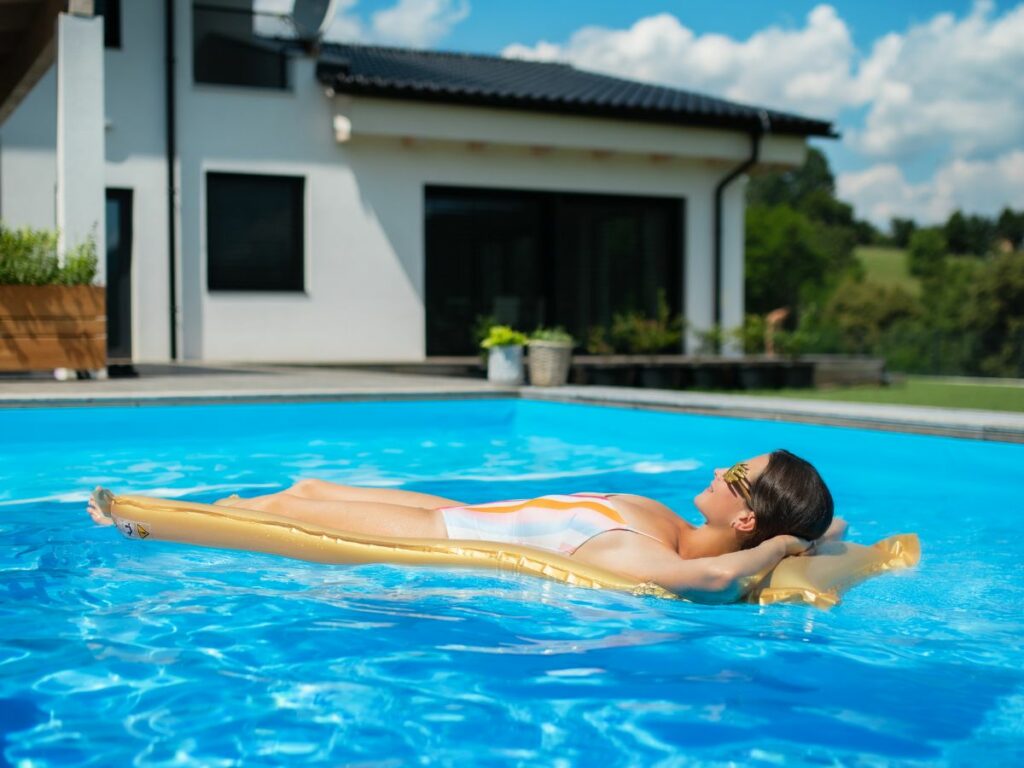 A woman laying on a floating raft in a swimming pool.