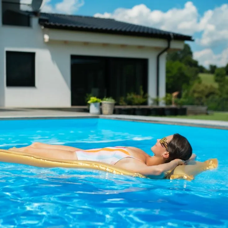 A woman laying on an inflatable float in a swimming pool.