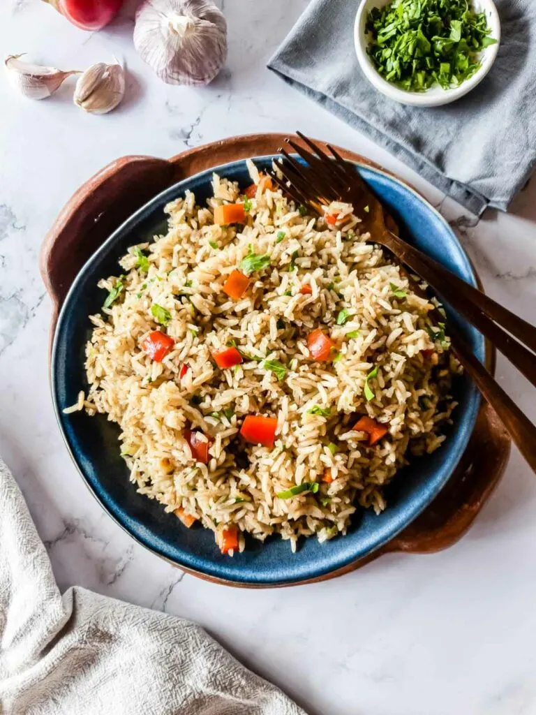 A plate of rice and vegetables on a marble countertop.