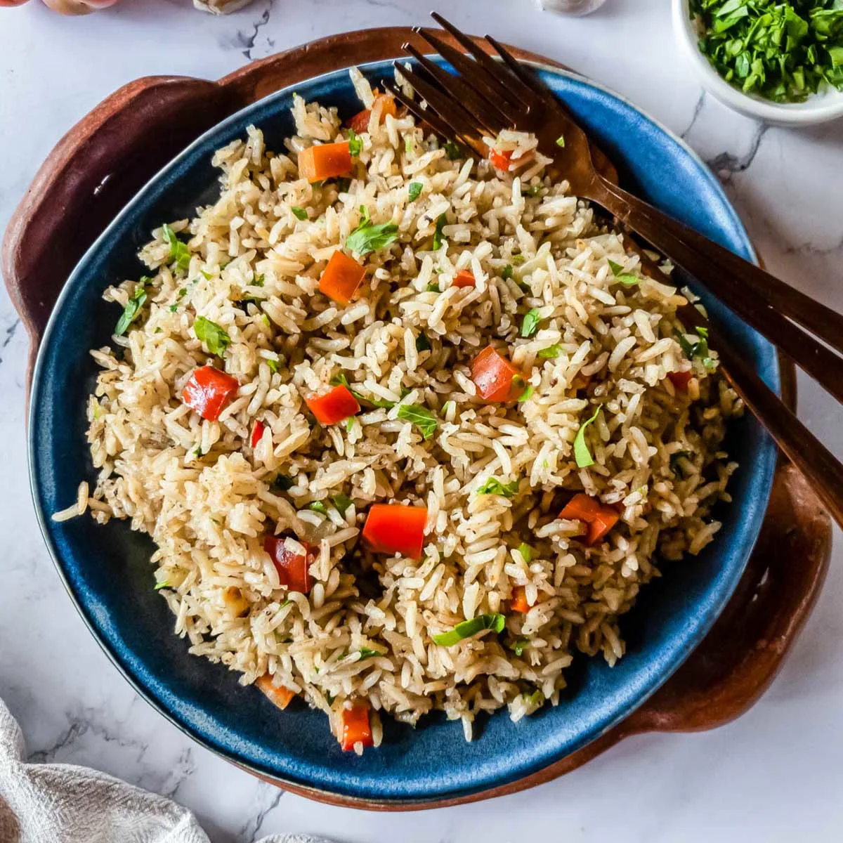 A bowl of rice with vegetables and herbs.