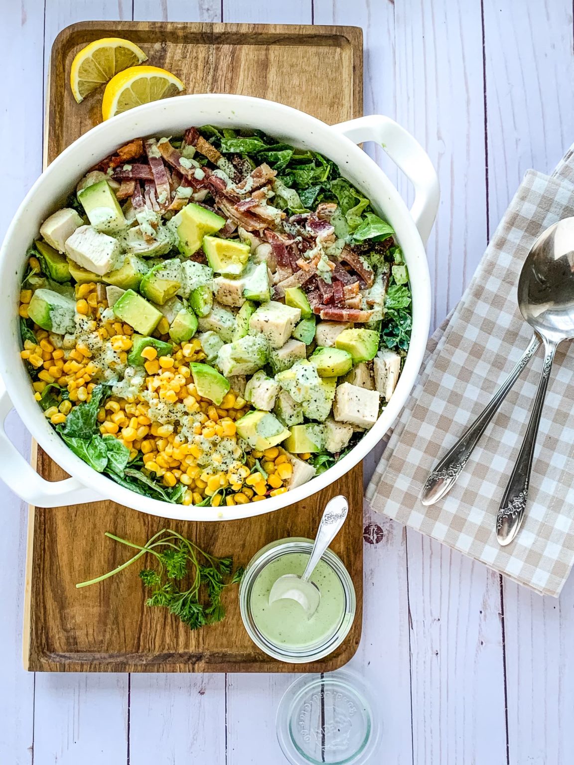 A white bowl with a chicken cobb salad on top of it.