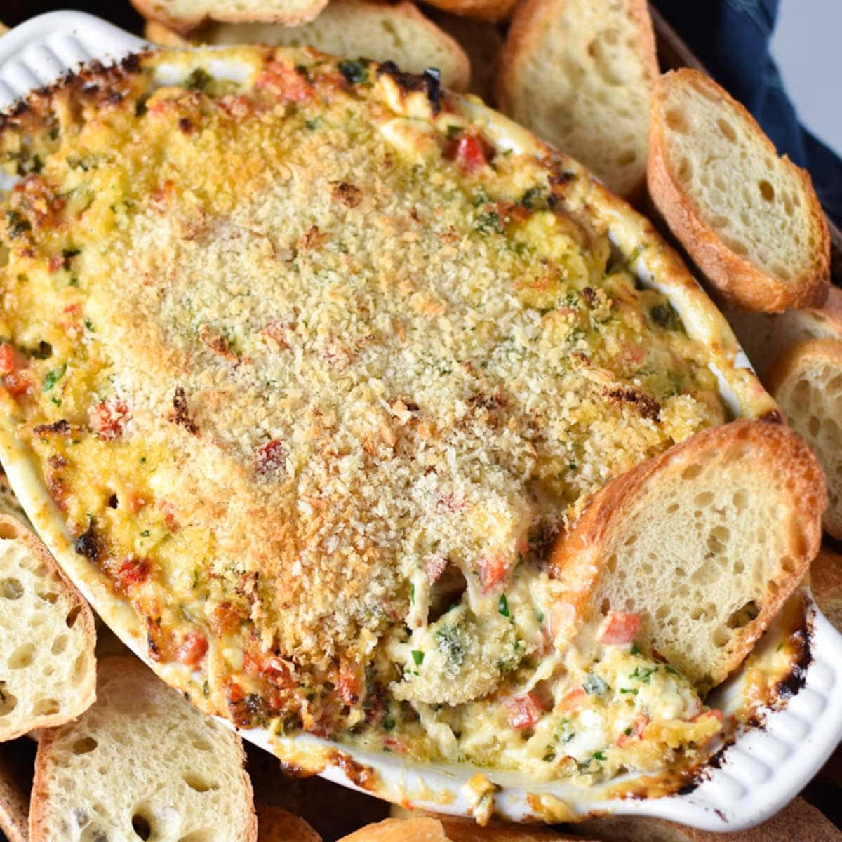A dish of crab dip with bread slices.