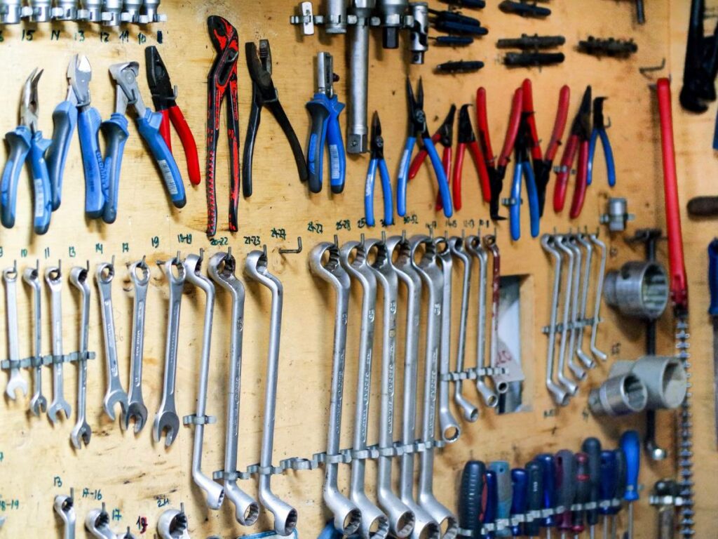 Decluttering a wall of tools in a garage with wall hangers.