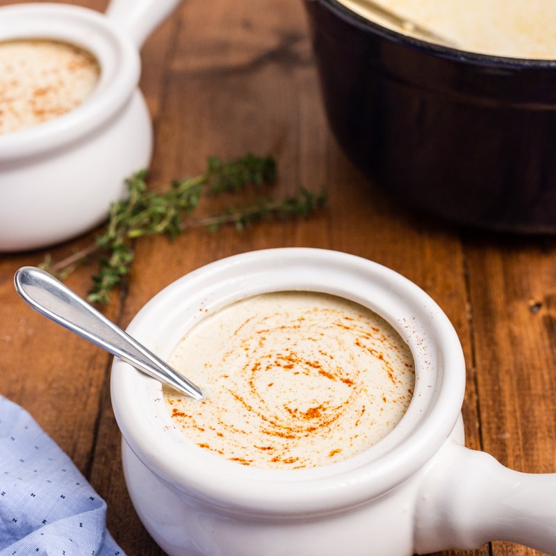 Two bowls of oyster stew on a wooden table.